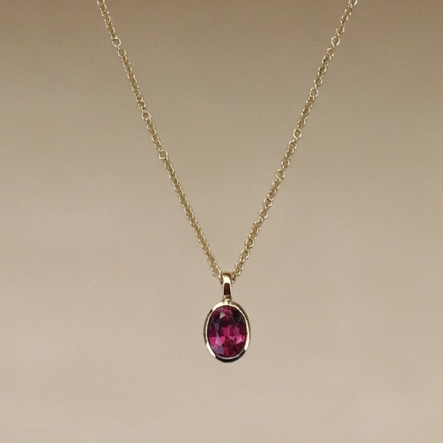 After — the same garnet, remade by Maisie into an everyday pendant